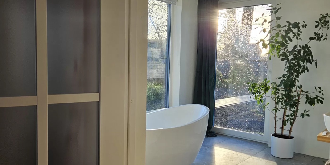 Brīvi stāvoša dizaina vanna pie loga AMRAI Lux mājā
